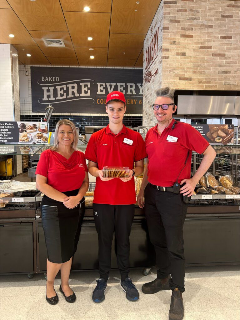 Olivia, Jakob and Coles manager Paul in front of Coles bakery